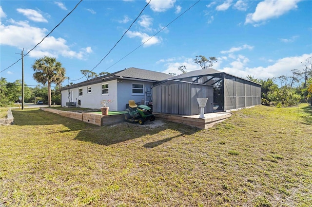 18033 Edgewater Dr, Port Charlotte, FL 33948 - rear view of house featuring glass enclosure, a lawn, and stucco siding