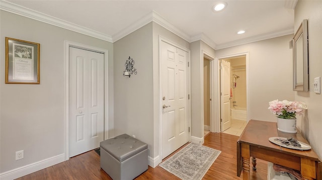 entryway with crown molding, wood finished floors, and recessed lighting
