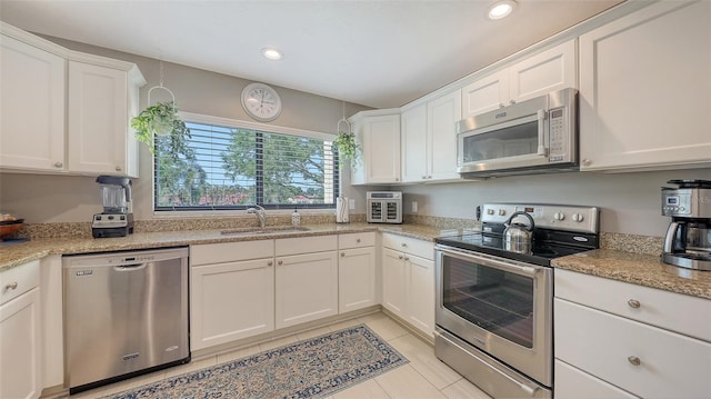 kitchen featuring white cabinets, a sink, recessed lighting, light stone countertops, and stainless steel appliances