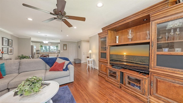 living room featuring recessed lighting, ornamental molding, and wood finished floors