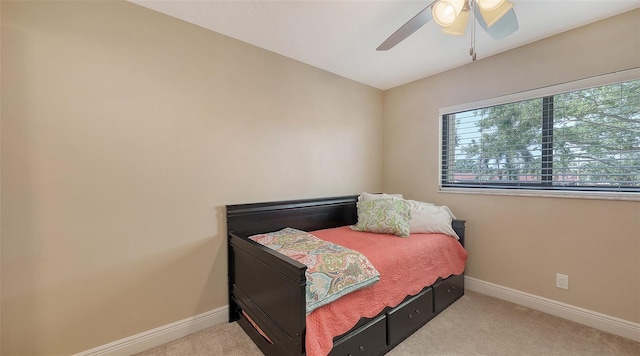 carpeted bedroom featuring baseboards and a ceiling fan