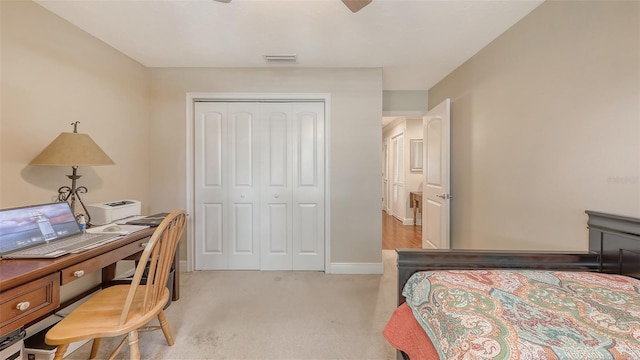 bedroom featuring baseboards, a closet, a ceiling fan, visible vents, and light colored carpet