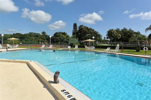 community pool with fence and a patio