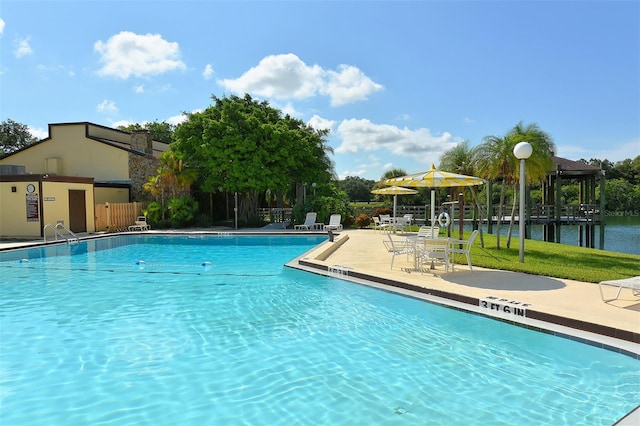community pool featuring a yard, a patio area, and fence