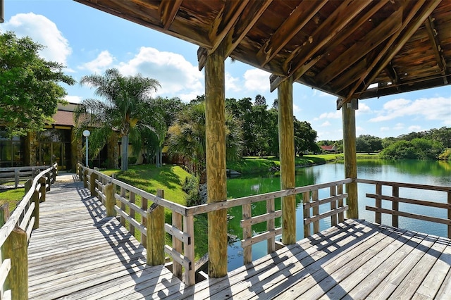 dock area with a water view and a yard
