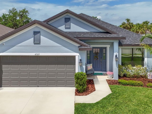 4509 95th Ter E, Parrish, FL 34219 - single story home with a garage, roof with shingles, a front lawn, and stucco siding