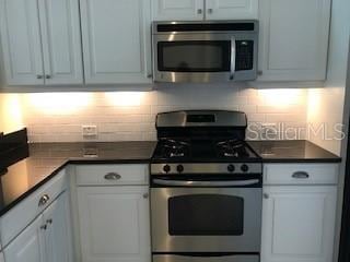 kitchen with white cabinetry, stainless steel appliances, and decorative backsplash