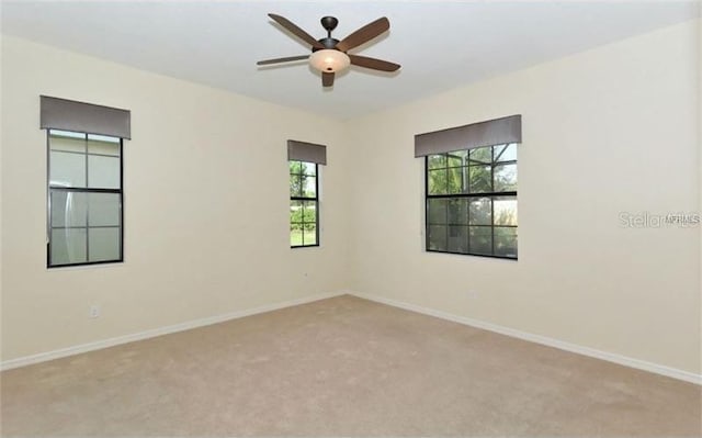 spare room featuring baseboards, ceiling fan, and carpet flooring