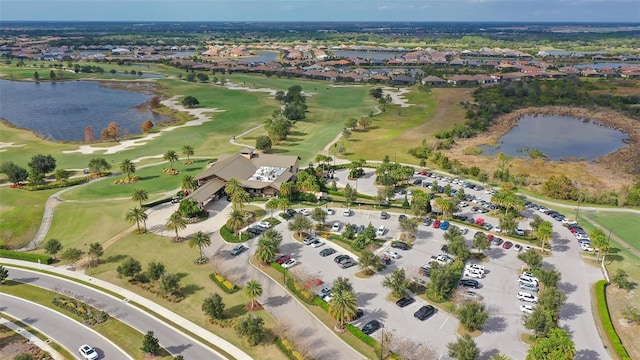 bird's eye view featuring golf course view, a water view, and a residential view
