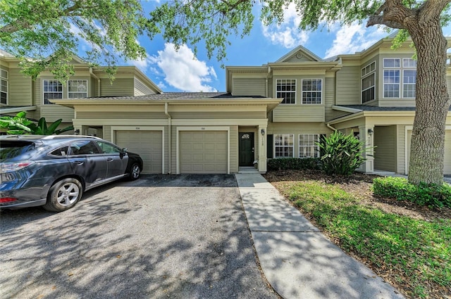 multi unit property with an attached garage and aphalt driveway