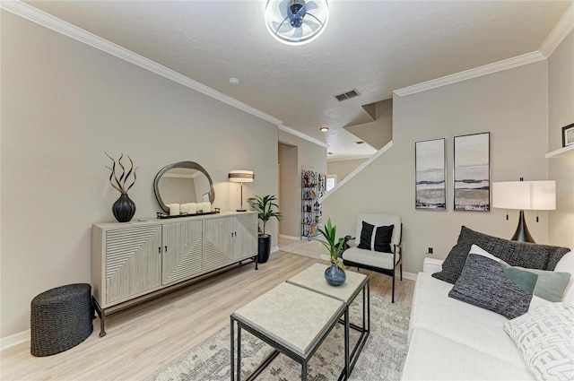 living area with light wood-style flooring, baseboards, ornamental molding, and visible vents