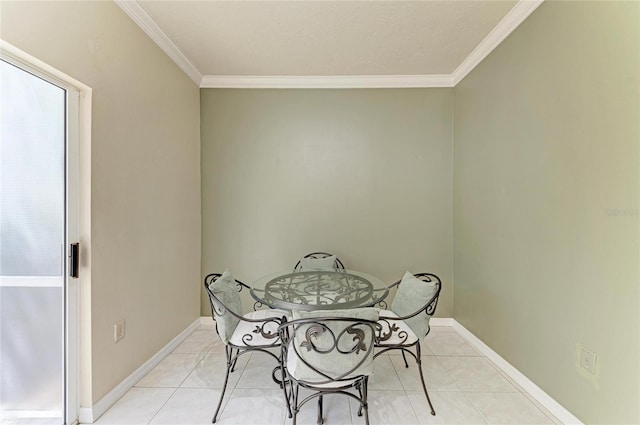 dining space with baseboards, crown molding, and light tile patterned flooring