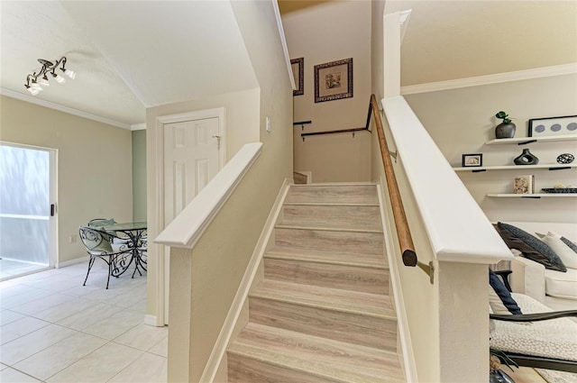 stairway with crown molding, tile patterned floors, and baseboards