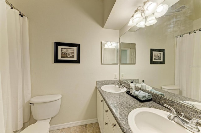 bathroom with toilet, double vanity, a sink, and visible vents