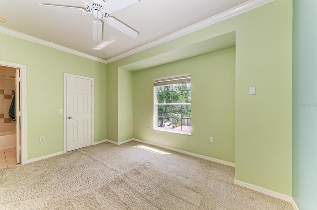 carpeted empty room featuring baseboards, ornamental molding, and a ceiling fan