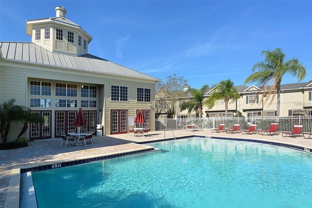 community pool featuring a patio, french doors, and fence