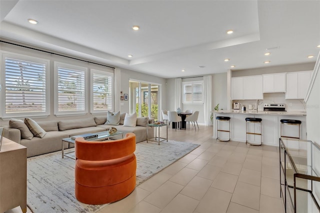 living room featuring a tray ceiling and recessed lighting