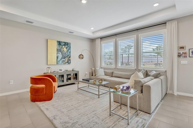 tiled living area featuring a raised ceiling, baseboards, visible vents, and recessed lighting