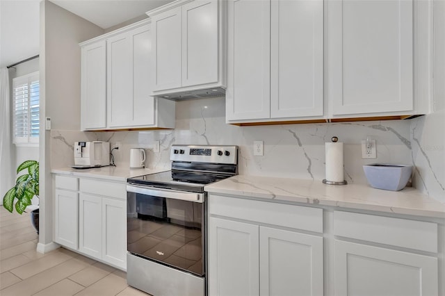 kitchen with white cabinets, stainless steel electric stove, under cabinet range hood, decorative backsplash, and light stone counters