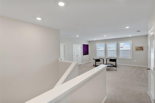 hallway featuring recessed lighting, light colored carpet, and baseboards