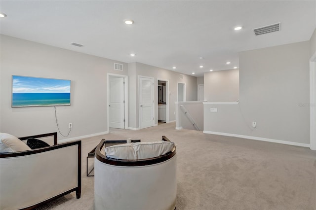 living area with visible vents, baseboards, recessed lighting, and light carpet