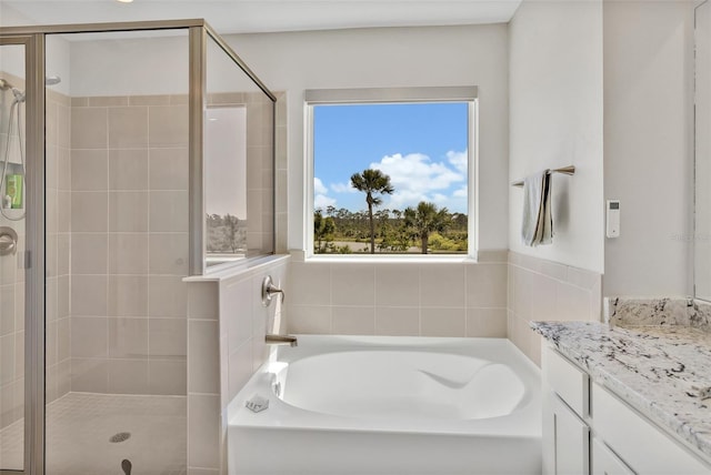 bathroom featuring vanity, a garden tub, and a stall shower
