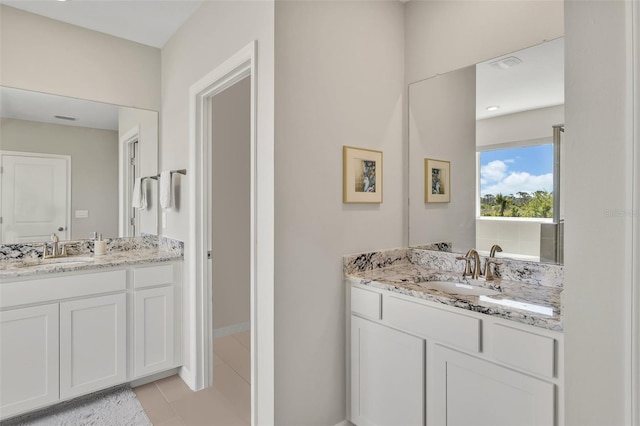 full bath featuring two vanities, a sink, and tile patterned flooring