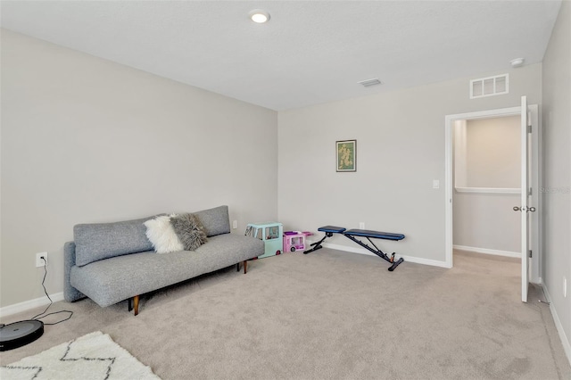 living area with visible vents, baseboards, and carpet flooring