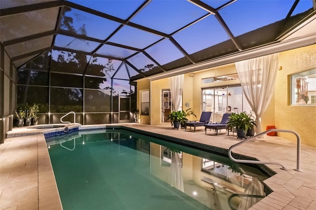 2196 Muskogee Trl, Nokomis, FL 34275 - pool at dusk with a patio, a pool with connected hot tub, glass enclosure, and a ceiling fan