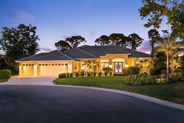 2196 Muskogee Trl, Nokomis, FL 34275 - mediterranean / spanish-style house featuring french doors, an attached garage, a yard, driveway, and a tile roof