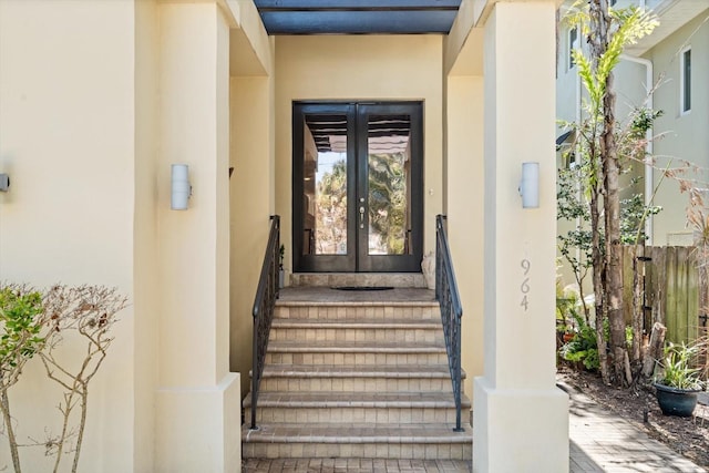 view of exterior entry featuring french doors and stucco siding