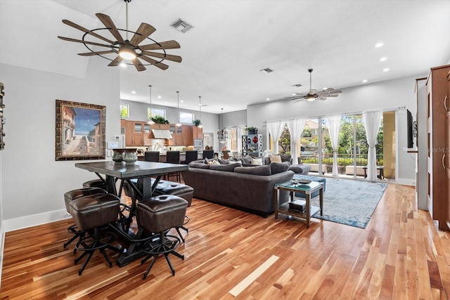 living room featuring visible vents, baseboards, ceiling fan, recessed lighting, and light wood finished floors