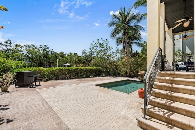 outdoor pool with a ceiling fan, a patio, and stairway