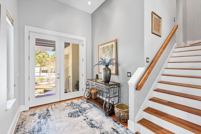 entrance foyer with french doors, wood finished floors, and stairs