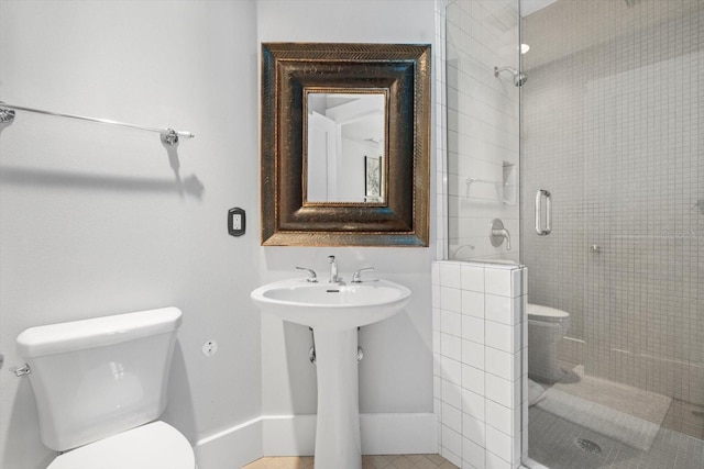 bathroom with a sink, toilet, and a shower stall
