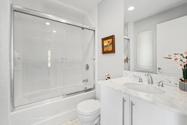 bathroom featuring combined bath / shower with glass door, recessed lighting, vanity, and toilet