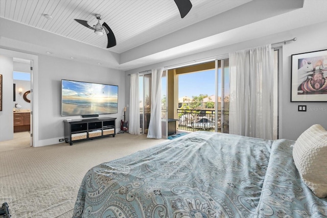 carpeted bedroom featuring ensuite bathroom, a tray ceiling, a ceiling fan, access to exterior, and baseboards