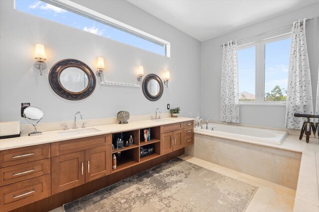 bathroom with a garden tub, double vanity, and a sink