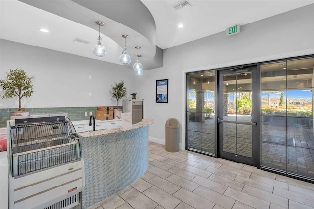 4704 Stafford Ct, Palmetto, FL 34221 - kitchen featuring light stone countertops, backsplash, recessed lighting, healthy amount of natural light, and hanging light fixtures