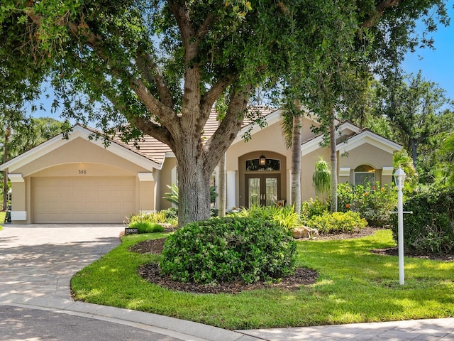 355 Melrose Ct, Venice, FL 34292 - view of front of home with stucco siding, a garage, french doors, and concrete driveway