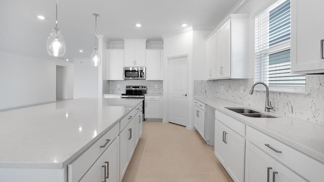 1599 Laurel Brook Ln, Port Charlotte, FL 33953 - kitchen with stainless steel appliances, a sink, a kitchen island, backsplash, and white cabinets