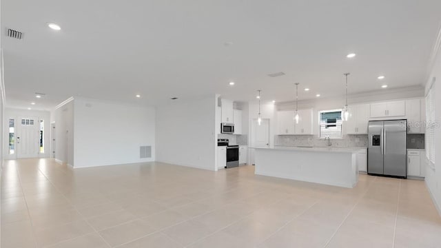1599 Laurel Brook Ln, Port Charlotte, FL 33953 - kitchen with appliances with stainless steel finishes, open floor plan, backsplash, a kitchen island, and light countertops