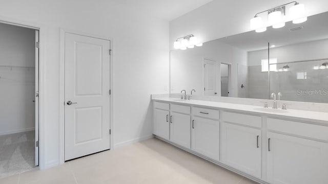 1599 Laurel Brook Ln, Port Charlotte, FL 33953 - bathroom featuring double vanity, tiled shower, a walk in closet, baseboards, and tile patterned floors