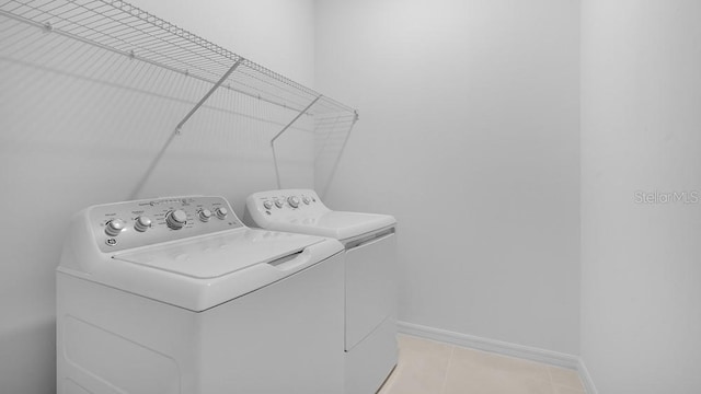 1599 Laurel Brook Ln, Port Charlotte, FL 33953 - washroom featuring washing machine and clothes dryer, light tile patterned floors, and baseboards