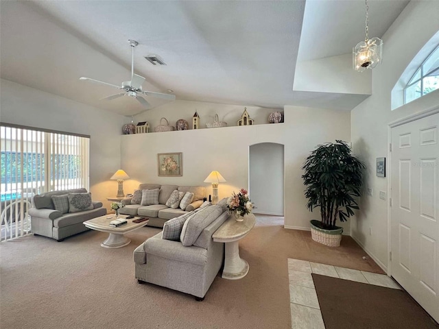living area featuring a wealth of natural light, visible vents, ceiling fan, and carpet flooring