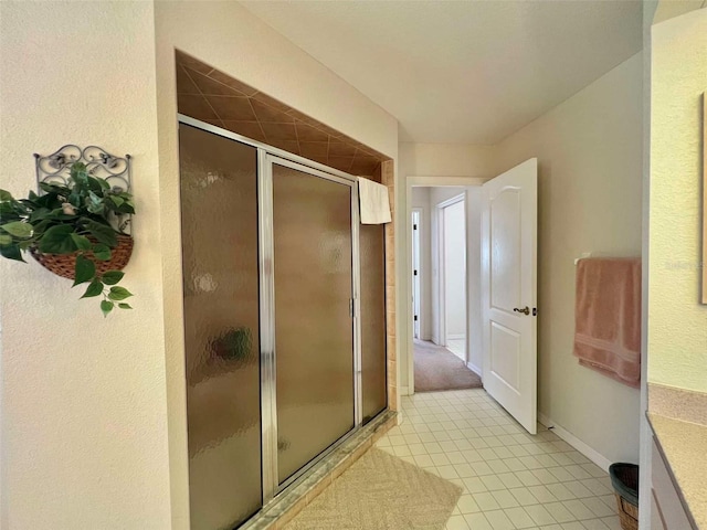 bathroom with baseboards, tile patterned floors, and a shower stall