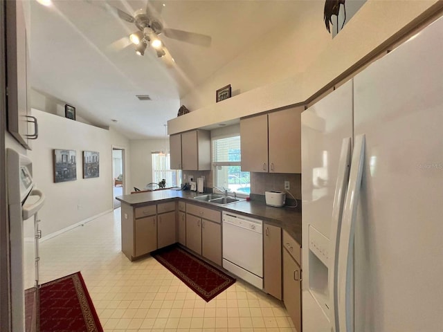 kitchen featuring a sink, a peninsula, white appliances, dark countertops, and ceiling fan