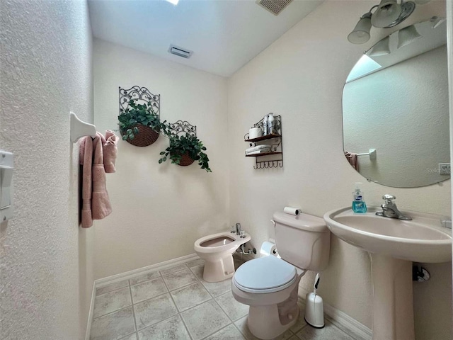half bathroom featuring baseboards, a bidet, toilet, and tile patterned floors