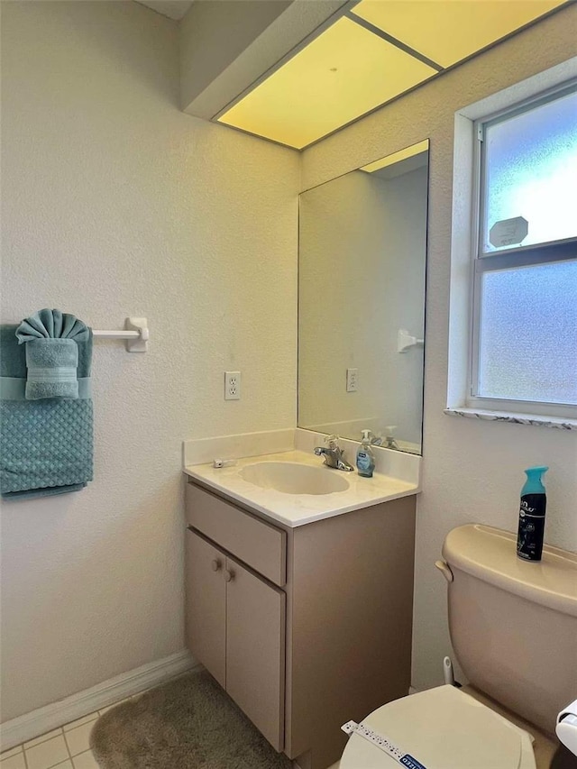 bathroom with baseboards, toilet, and vanity