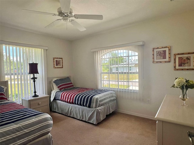 carpeted bedroom with baseboards and a ceiling fan